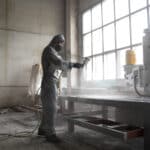 full-shot-man-spraying-powder-paint-from-gun